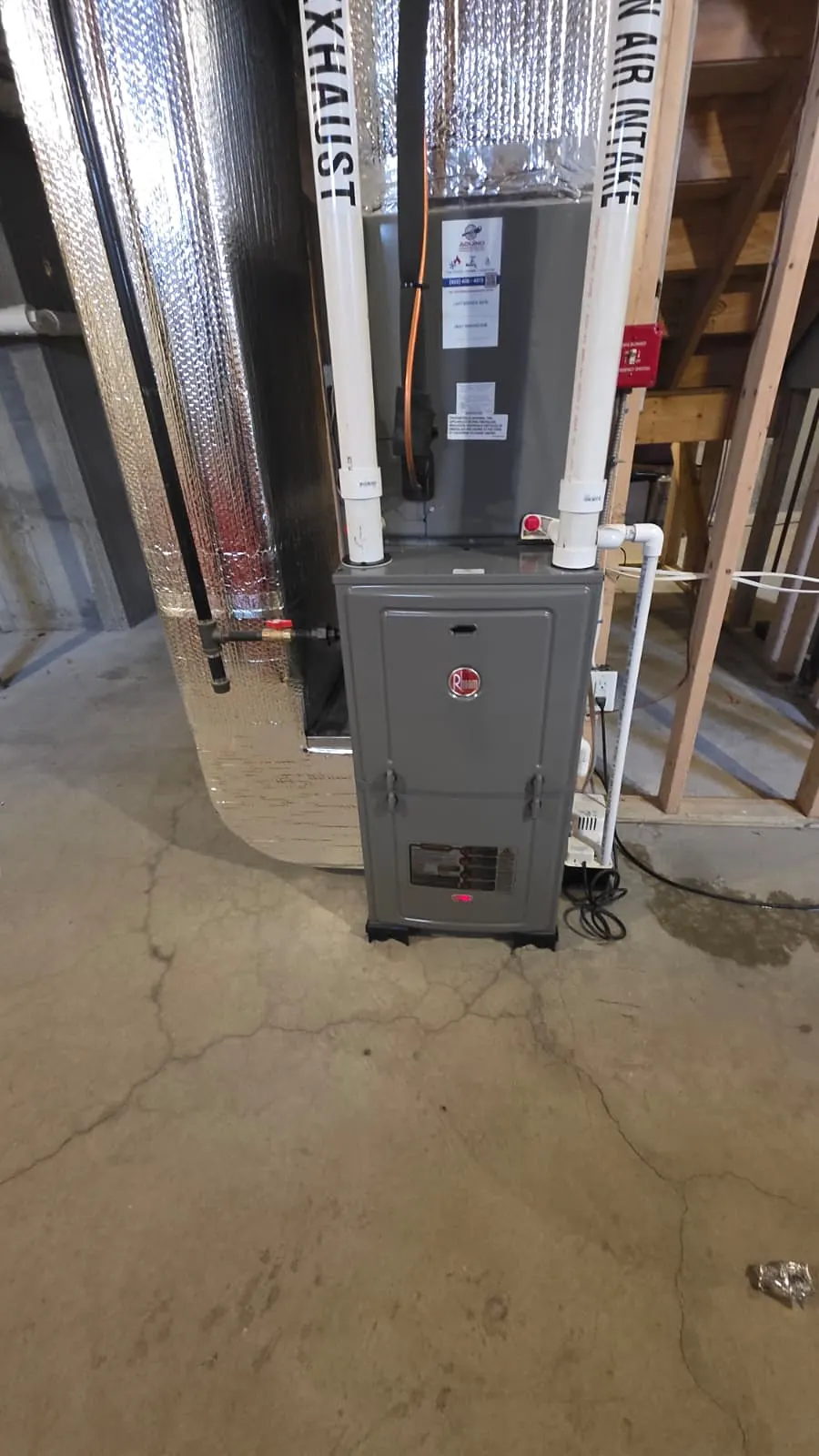 Gas furnace with PVC intake and exhaust pipes in an unfinished basement